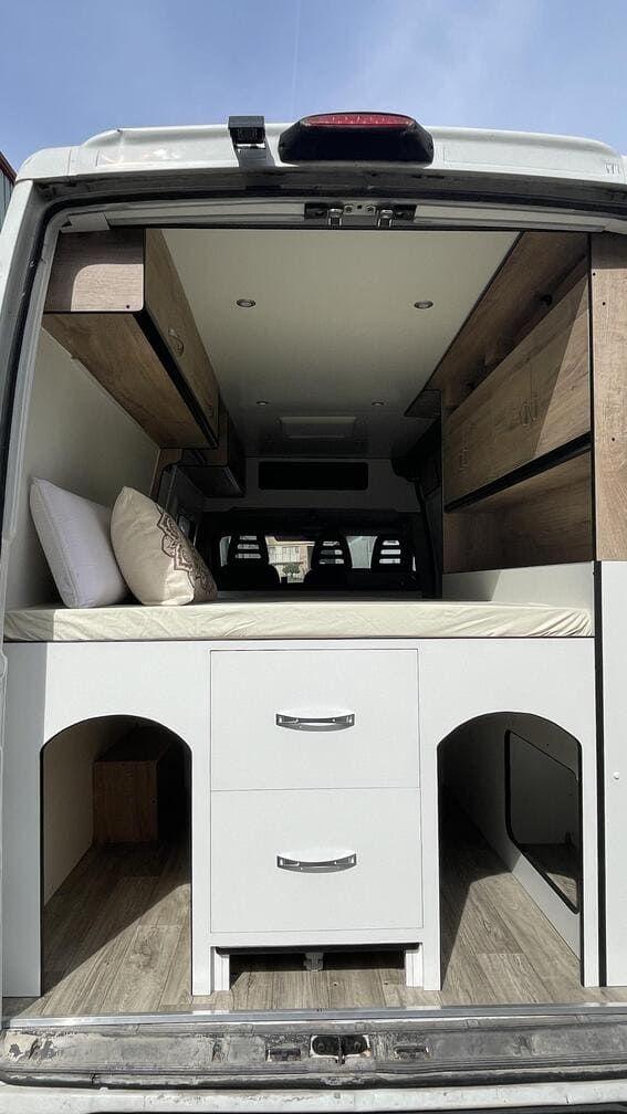 La parte trasera de una camioneta con una cama y cajones dentro.