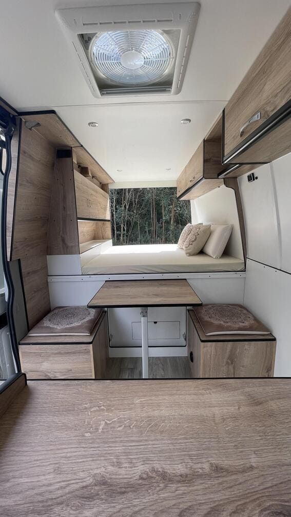El interior de una furgoneta con una cama y una mesa.