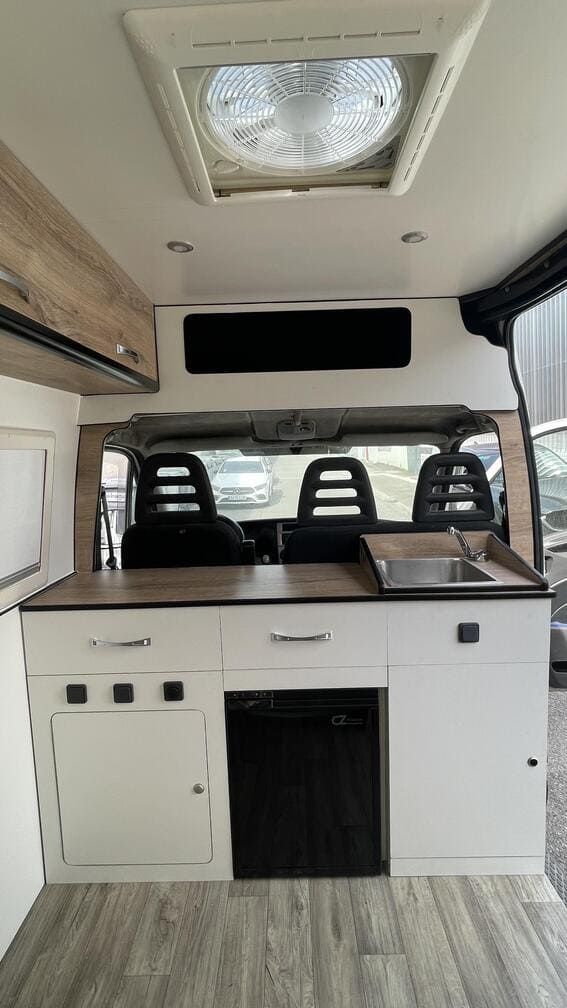 El interior de una furgoneta con cocina y fregadero.