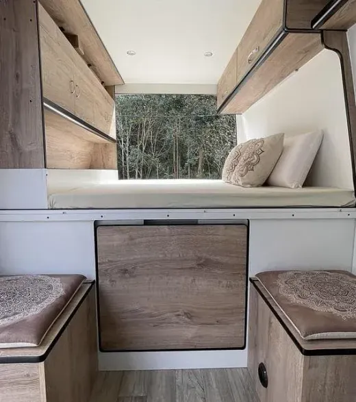 El interior de una furgoneta con una cama debajo.