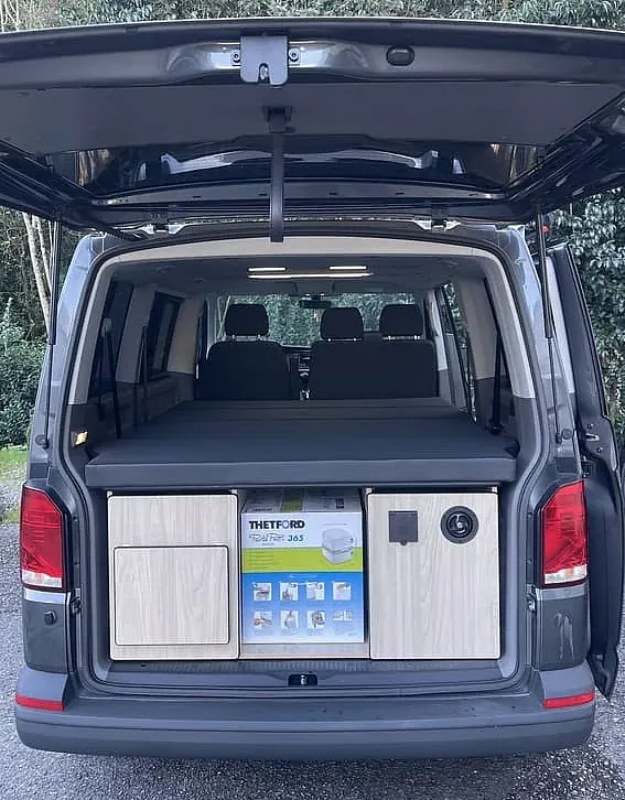 La parte trasera de una camioneta con el maletero abierto.