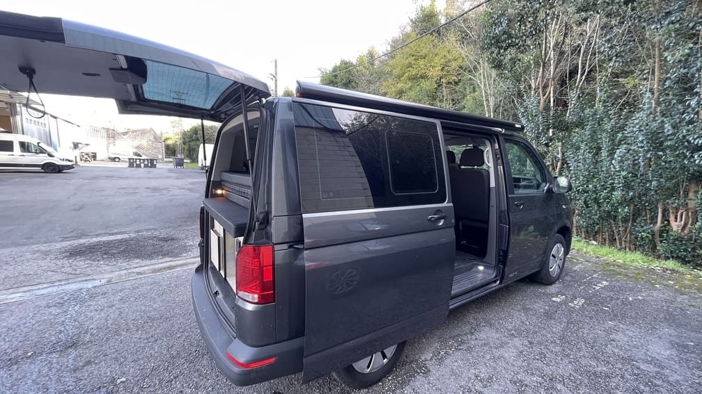 Una camioneta negra está estacionada en un estacionamiento con las puertas abiertas.