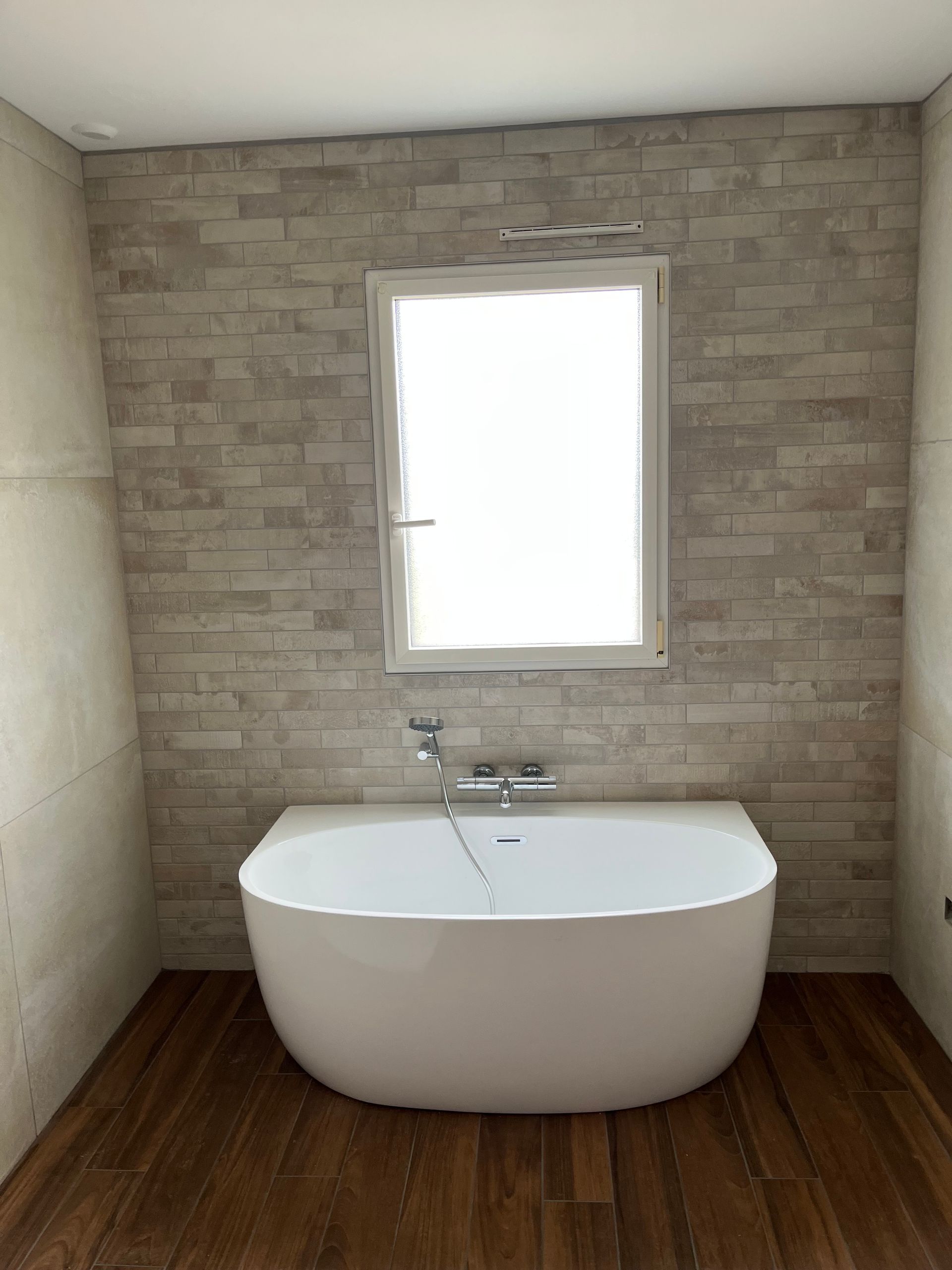 Une baignoire et du carrelage mural dans une salle de bains