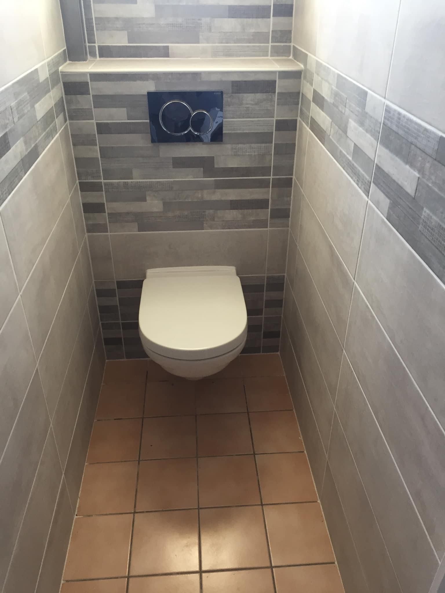 Une toilette avec du carrelage sur les murs 