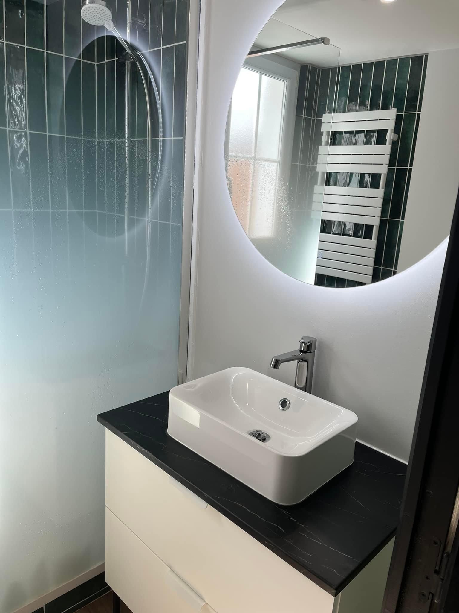 Salle de bains avec un évier et un miroir rond