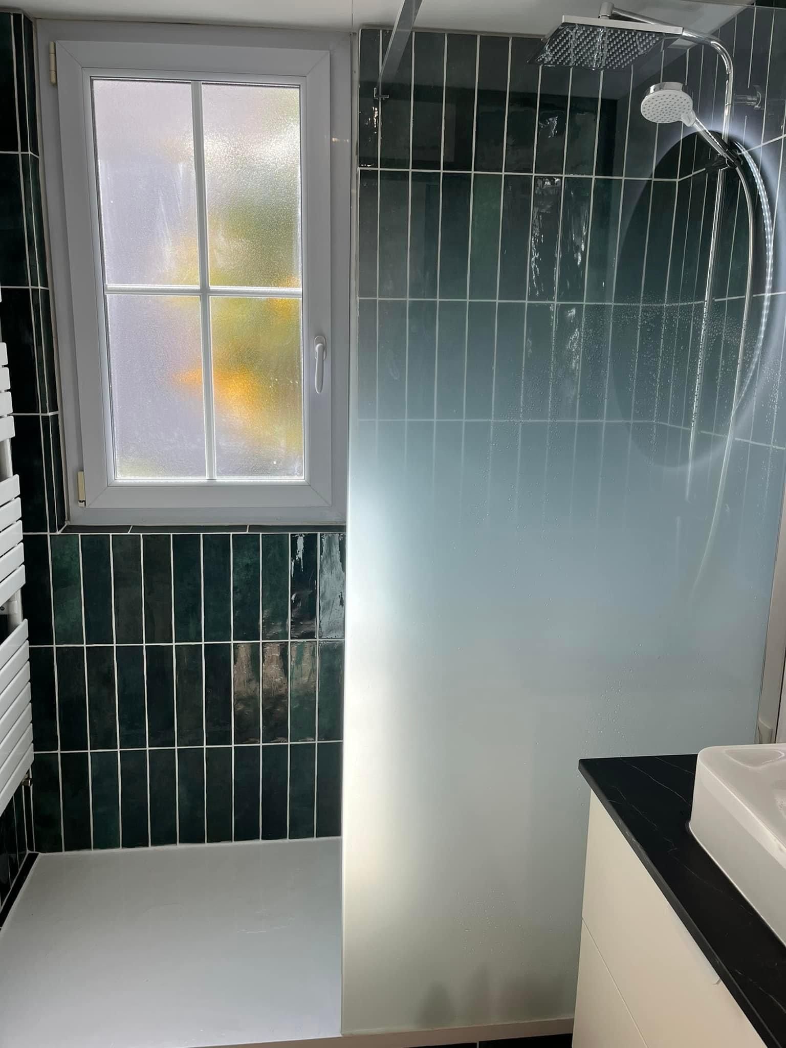 Salle de bains avec du carrelage vert sur les murs et une douche 