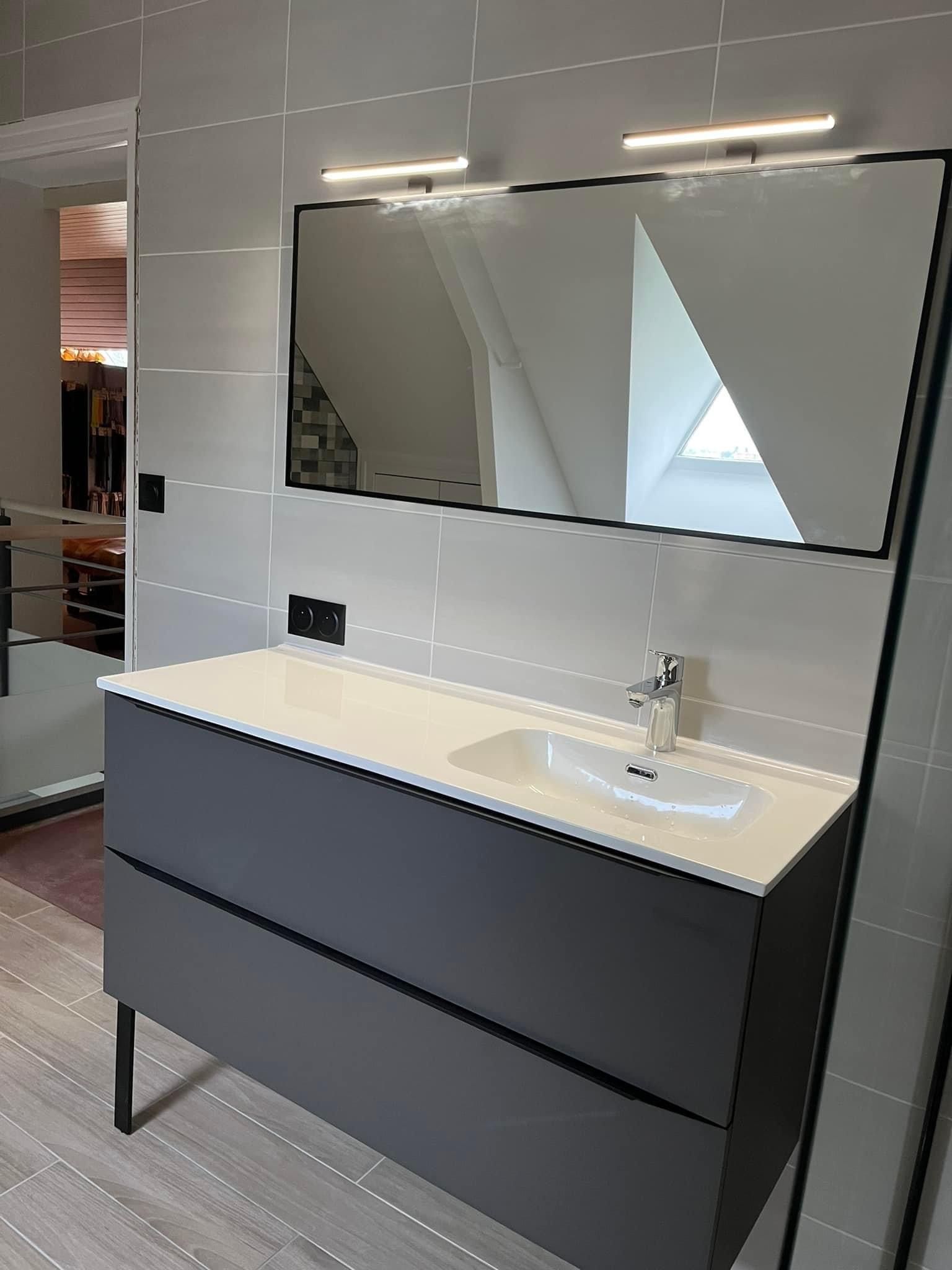 Salle de bains avec un lavabo, un miroir et du carrelage sur les murs