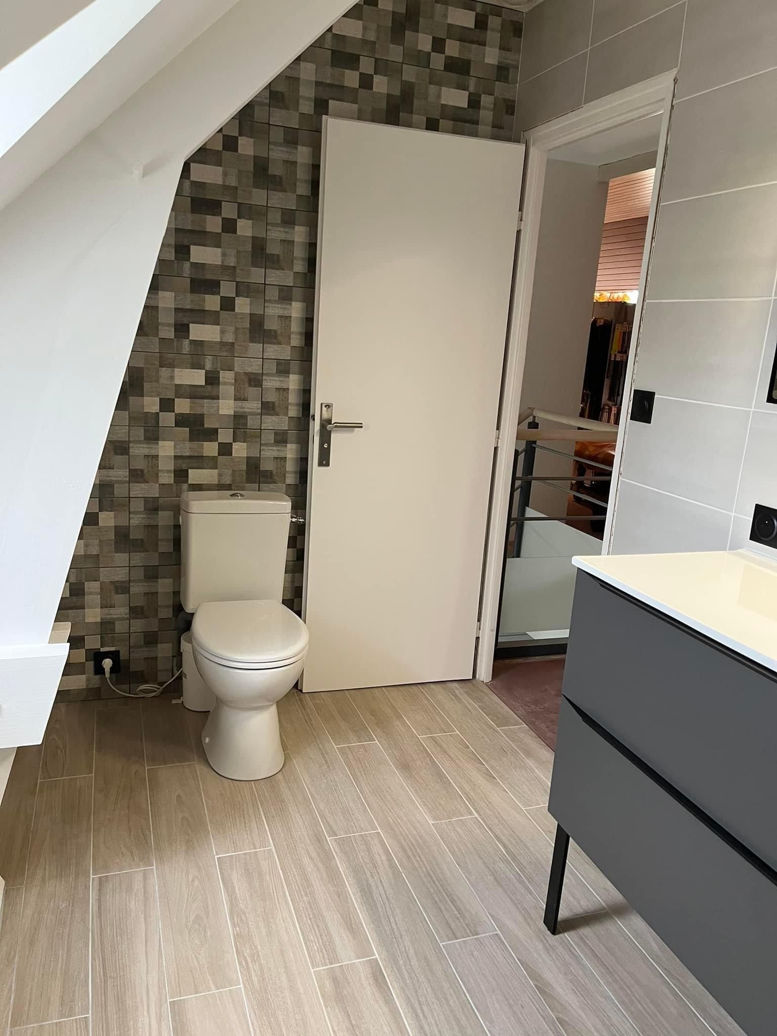 Salle de bains rénovée avec des toilettes et un lavabo 