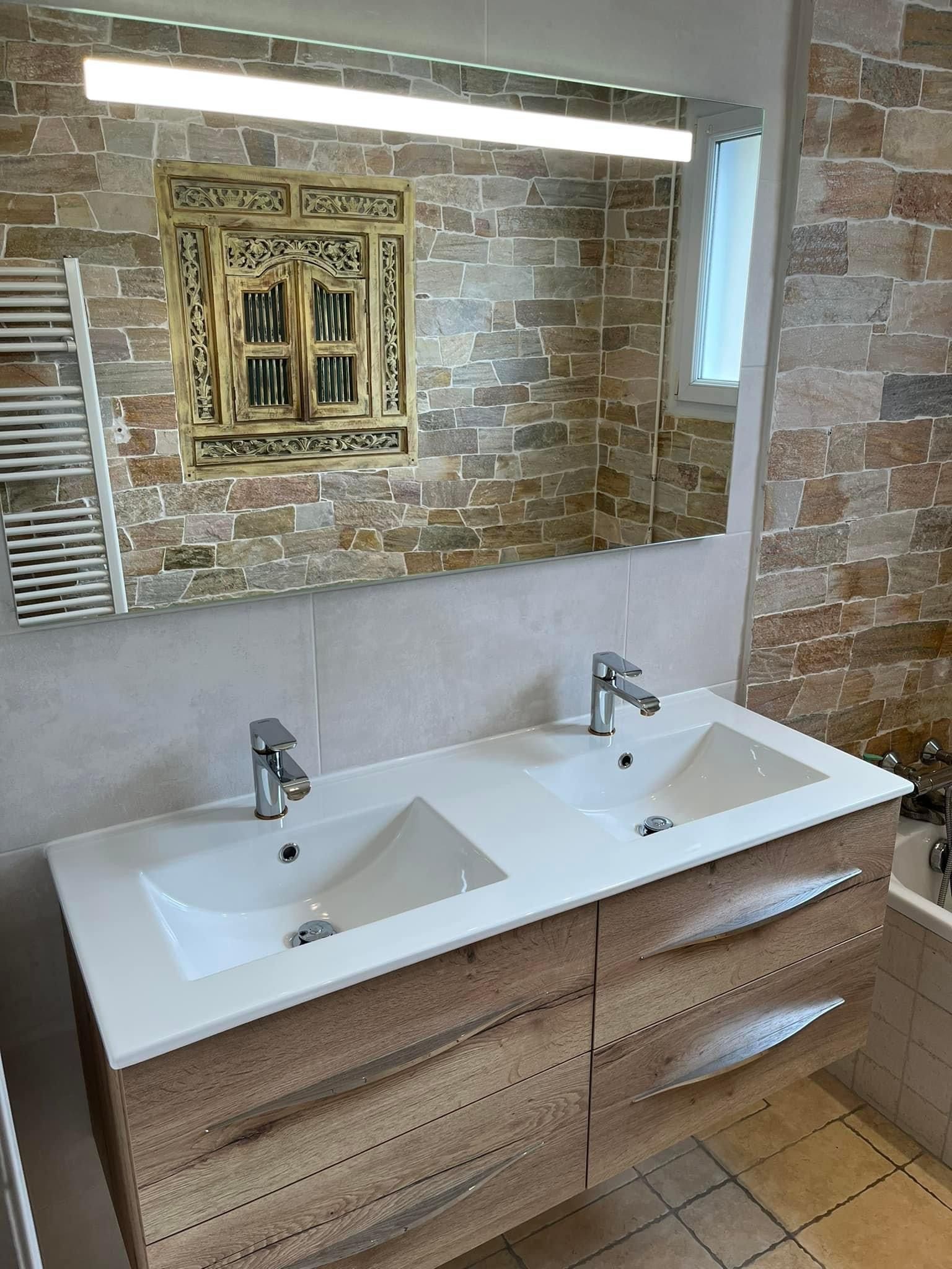 Deux éviers dans une salle de bains avec un mur en pierre