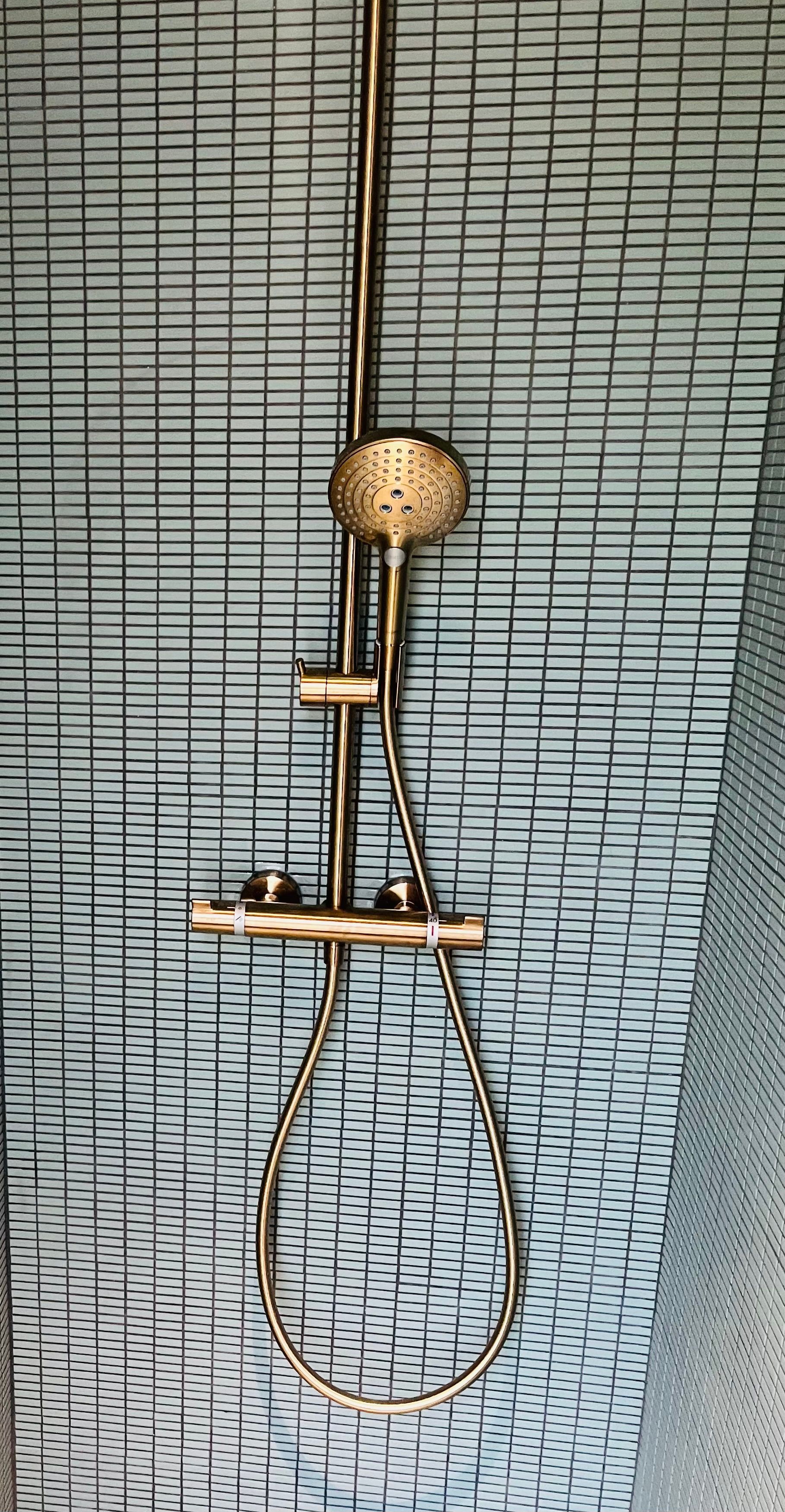 Un pommeau de douche et du carrelage mural