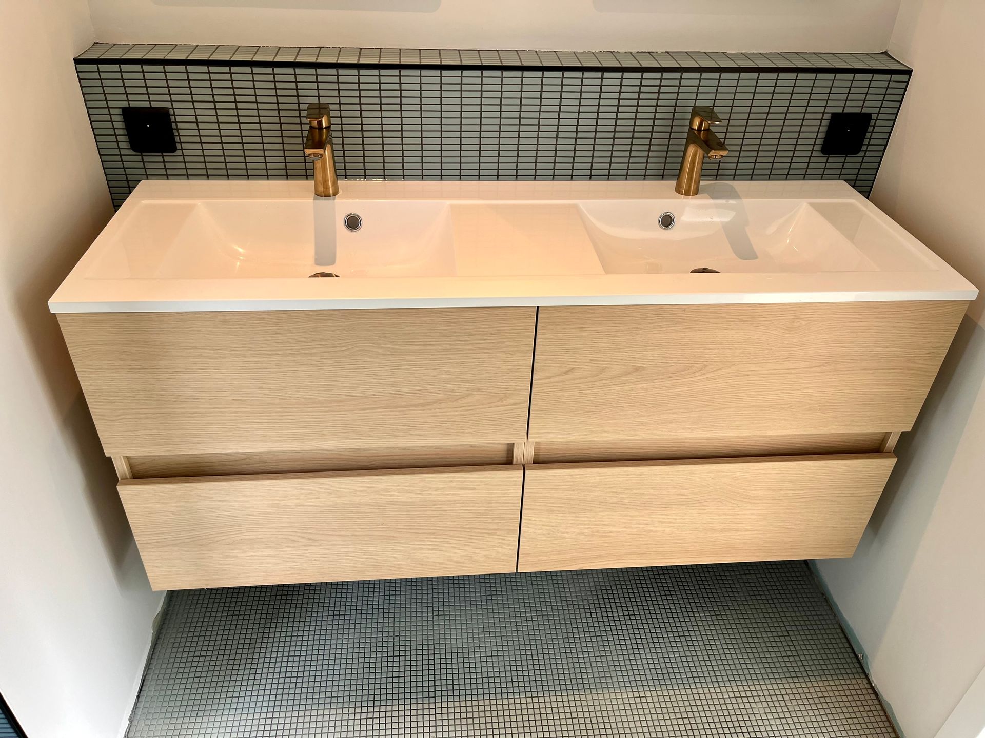 Deux lavabos dans une salle de bains avec du carrelage sur les murs