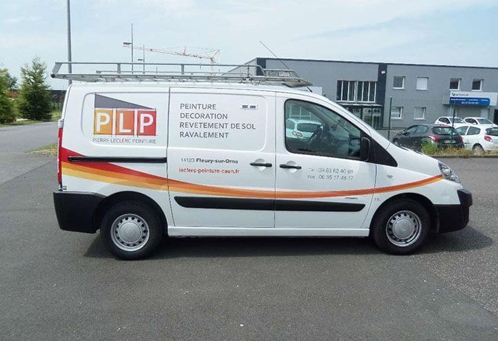 Fourgon PIP blanc avec une bande orange, garé devant un bâtiment, vue de profil.