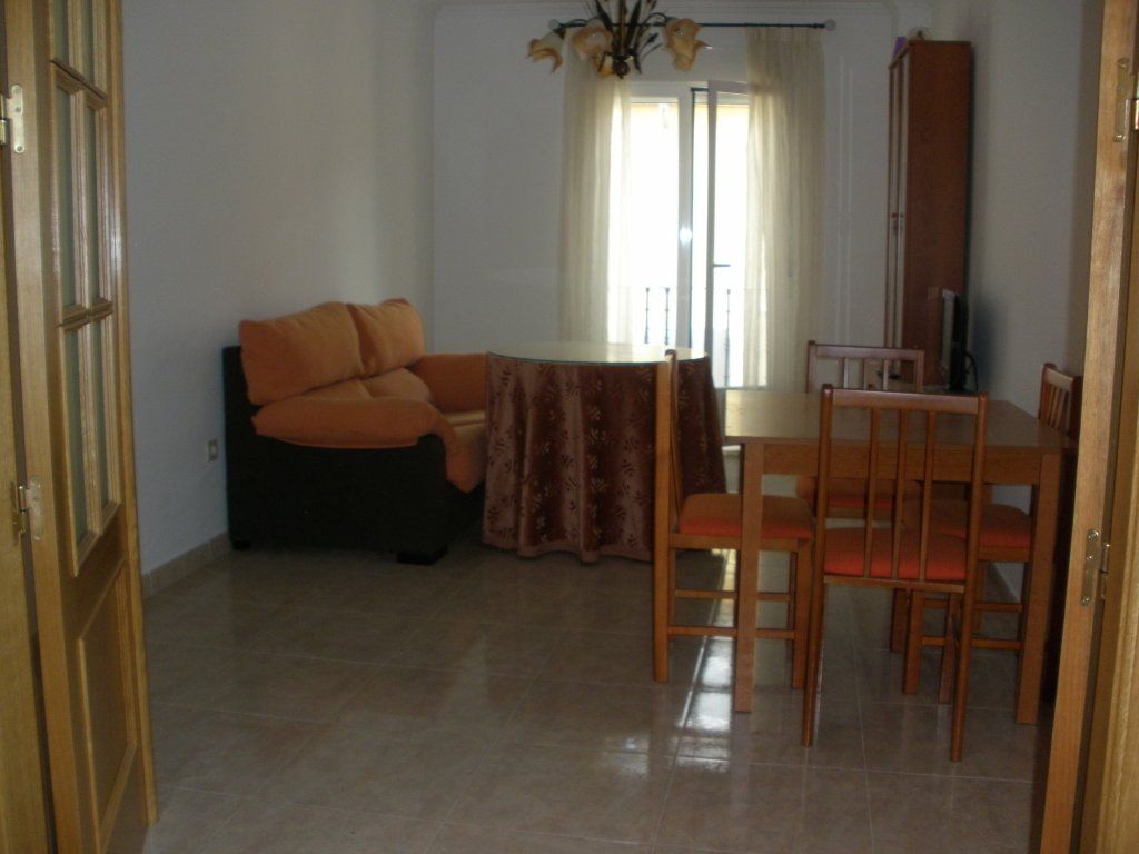 Una sala de estar con un sofá, una mesa y sillas.