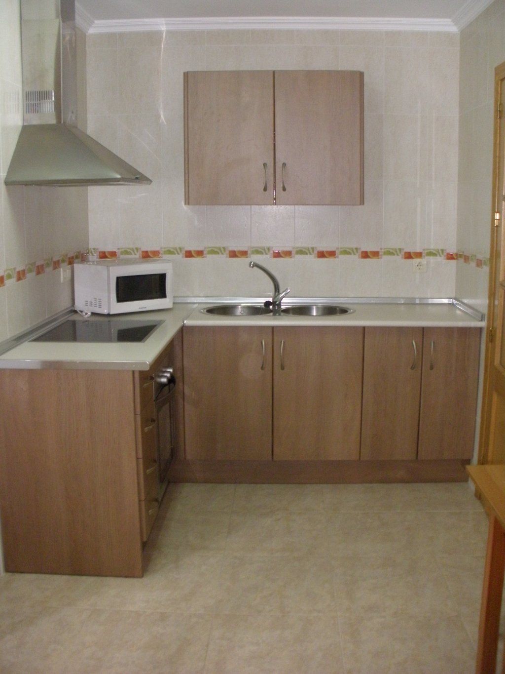 Una cocina con muebles de madera y microondas.