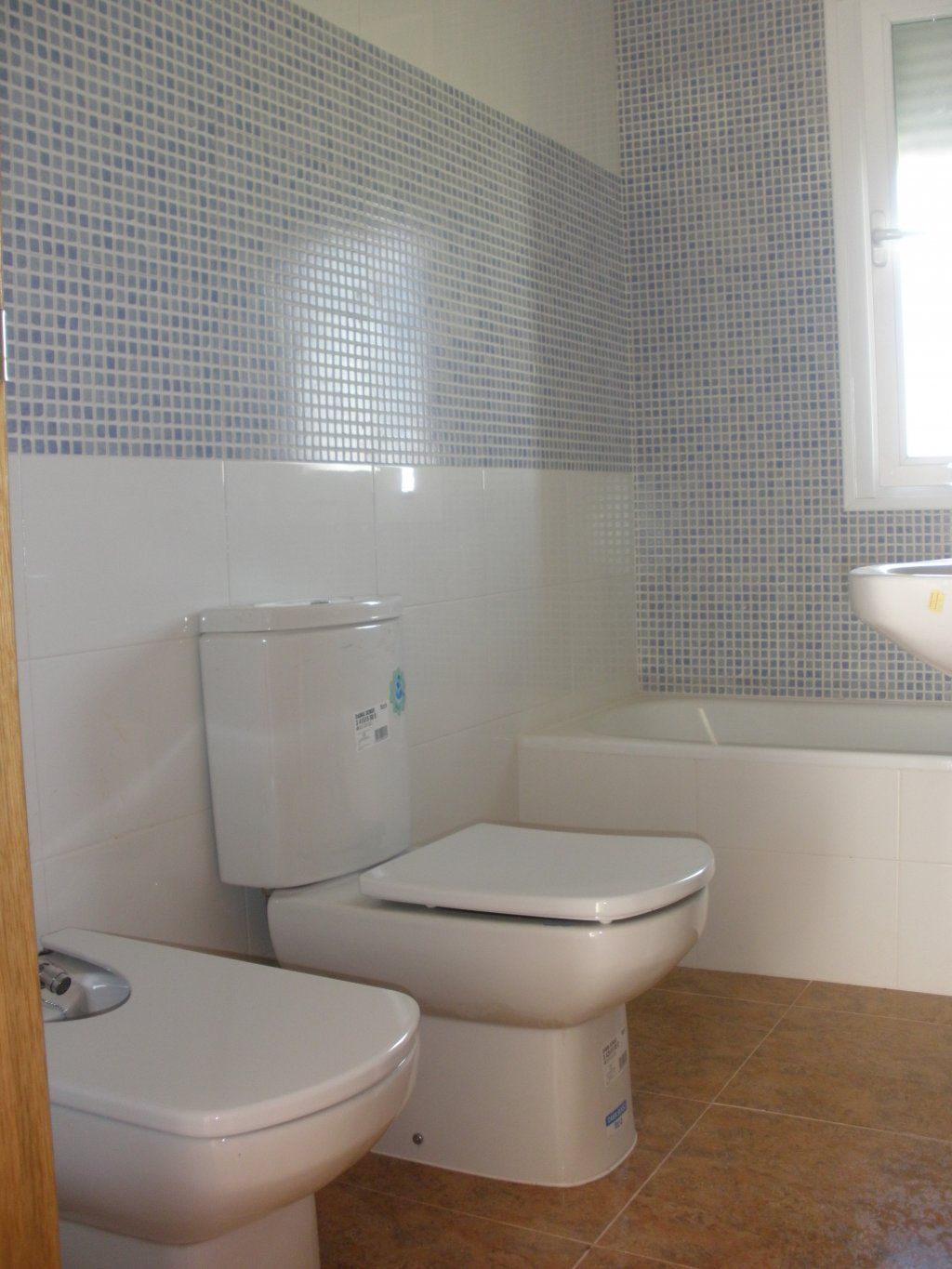 Un baño con inodoro, lavabo y bañera.