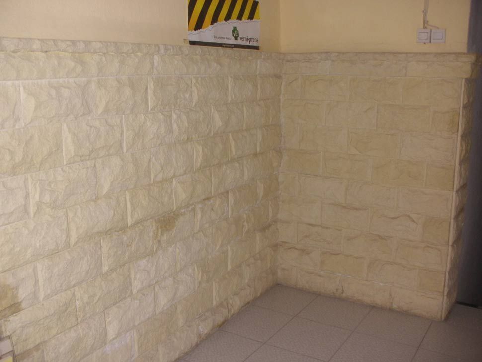Una habitación con una pared de ladrillos y un cartel en la pared.