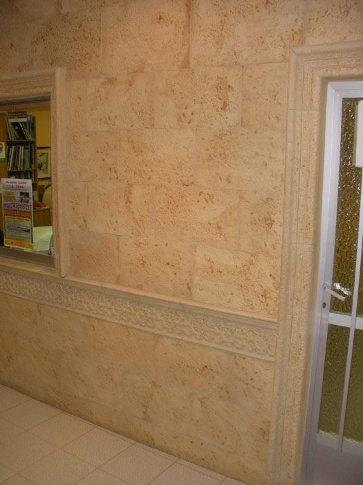 Una pared de ladrillos con una ventana y una puerta en una habitación.