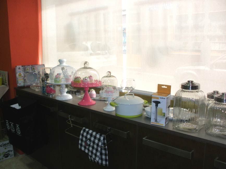 Una encimera de cocina con muchos frascos de cristal y platos encima.