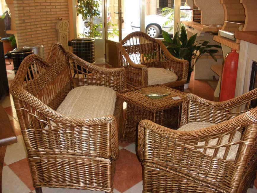 Un grupo de sillas de mimbre y una mesa en una habitación.