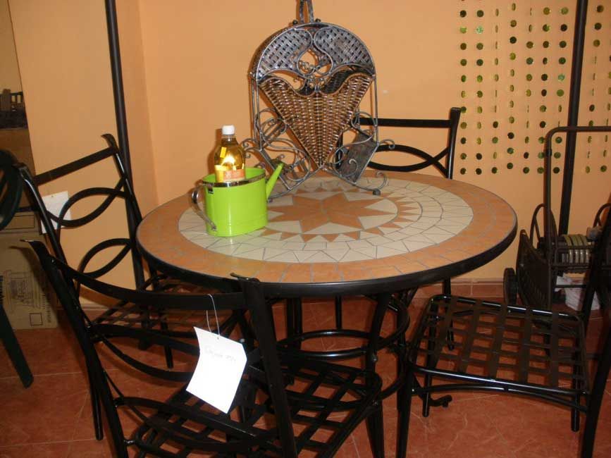 Una mesa con una regadera verde encima.