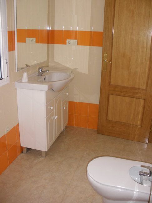 Un baño con lavabo, inodoro y espejo.