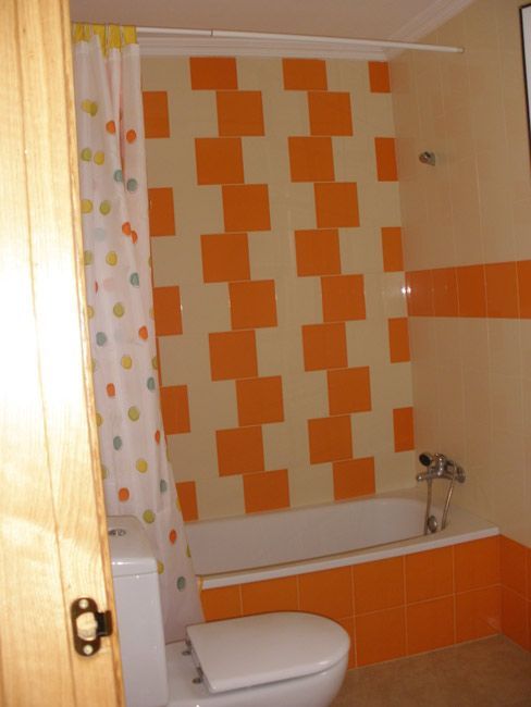 Un baño con inodoro, bañera y cortina de ducha.