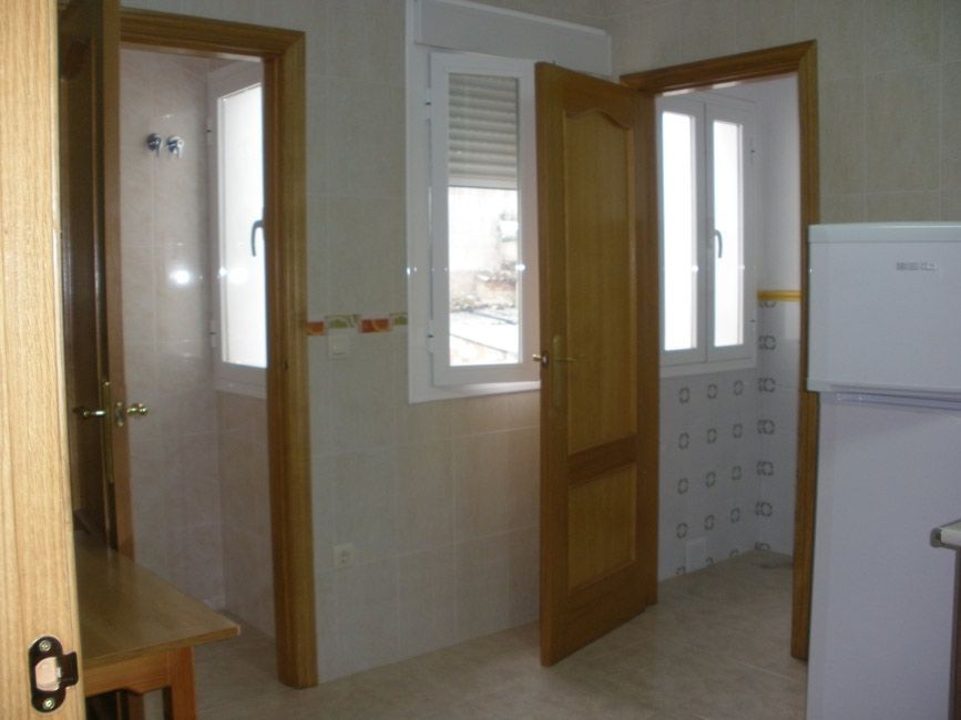 Una cocina con nevera y ventana.