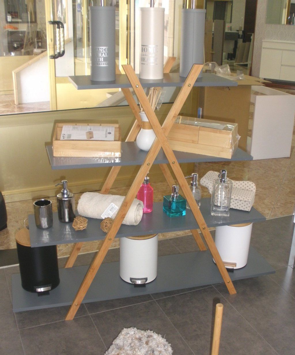 Un estante de madera lleno de diversos artículos, incluidas velas y dispensadores de jabón.