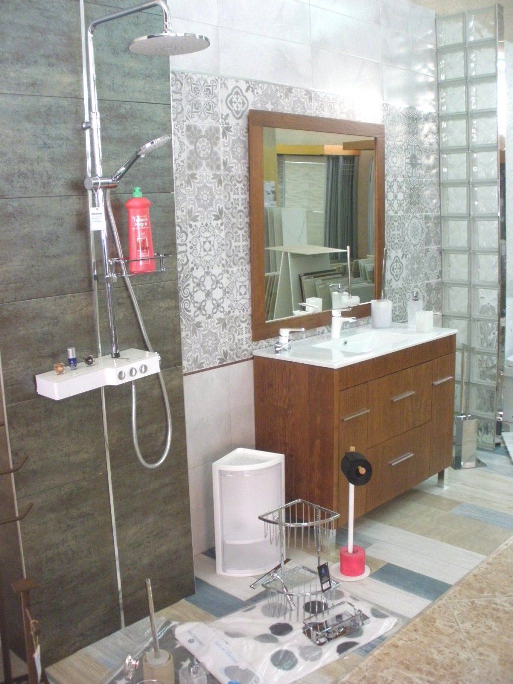 Un baño con lavabo, ducha y espejo.