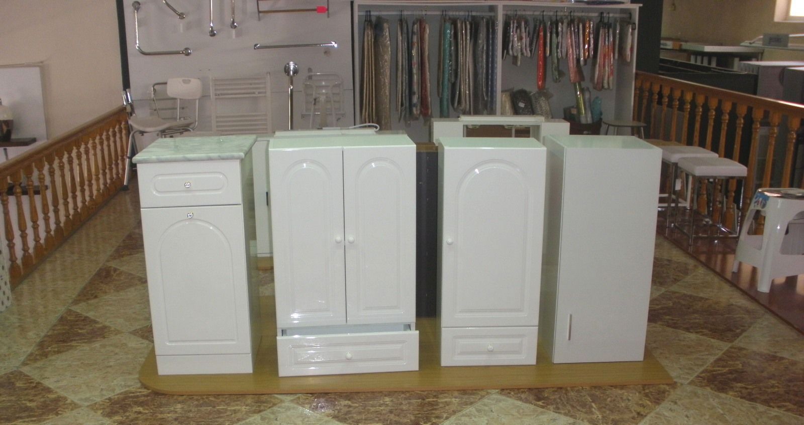 Un montón de armarios blancos se encuentran sobre un piso de baldosas en una habitación.