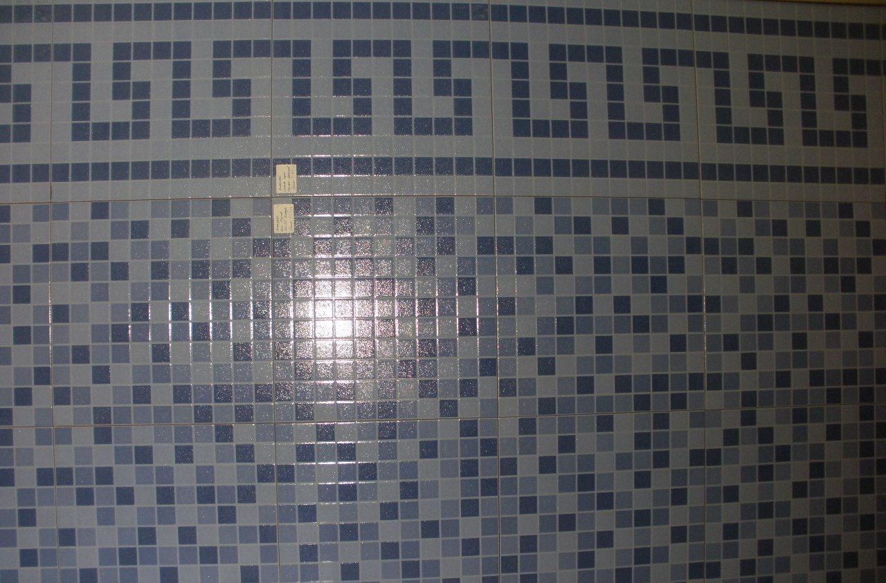 Una pared de azulejos azules y blancos con un diseño de clave griega.