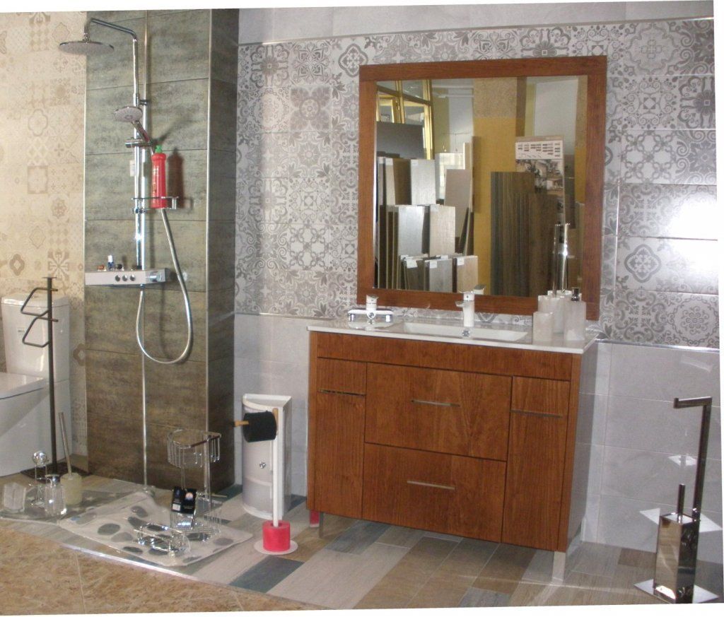 Un baño con un tocador de madera y un espejo grande.