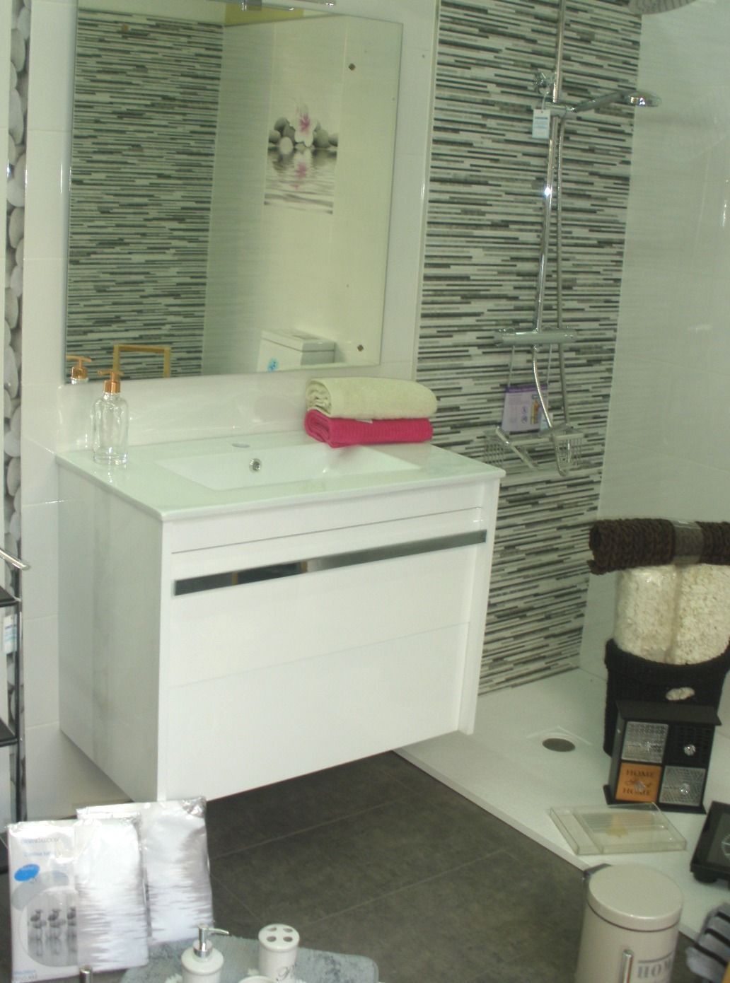 Un baño con lavabo, espejo y ducha.