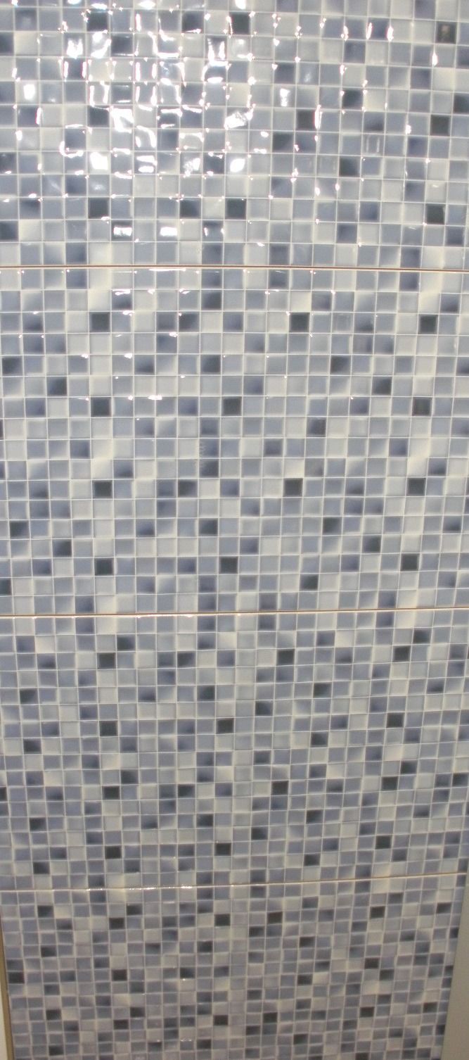 Un primer plano de una pared de mosaicos en un baño.