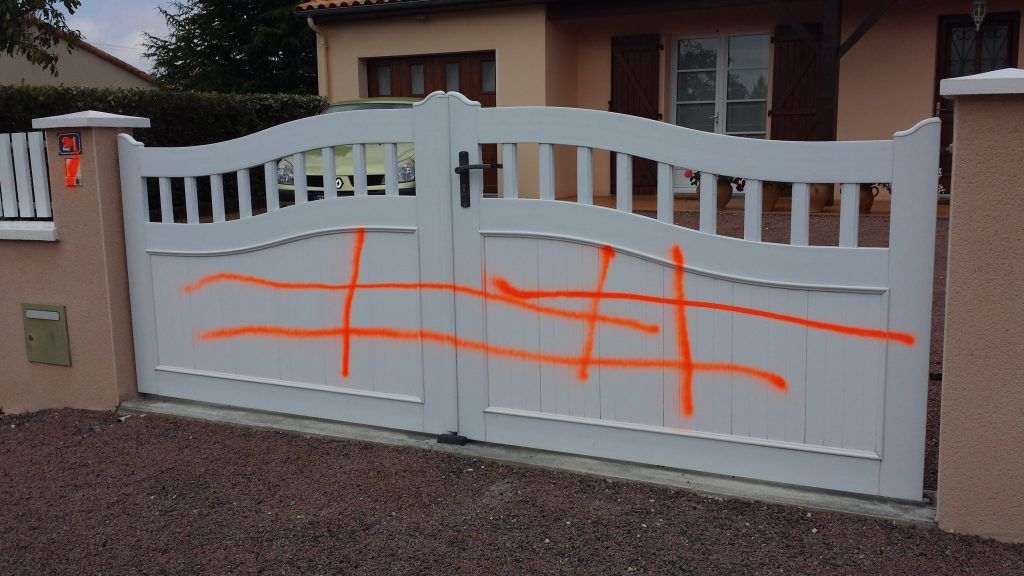 Portail blanc avec graffiti orange
