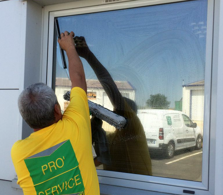 Homme portant un t shirt PRO SERVICE en train de laver une vitre