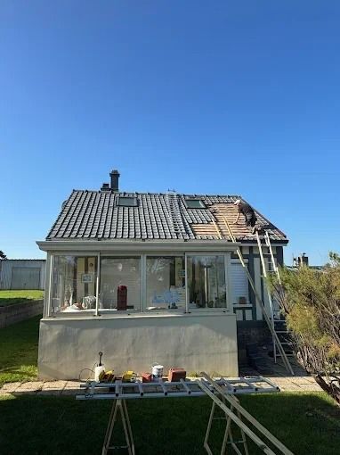 Maison dont la couverture est en cours de rénovation sous un ciel bleu