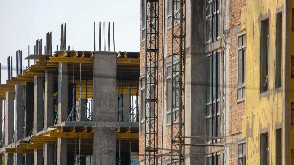 Ein im Bau befindliches Gebäude mit einem Kran im Hintergrund.