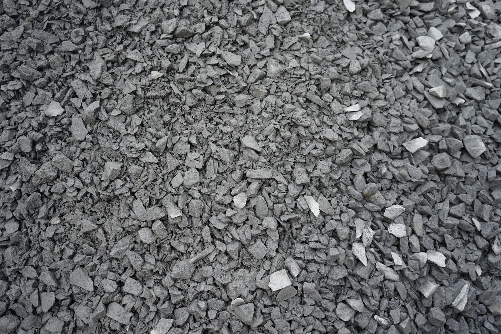 Auf dem Boden liegt ein Haufen grauer Kies.
