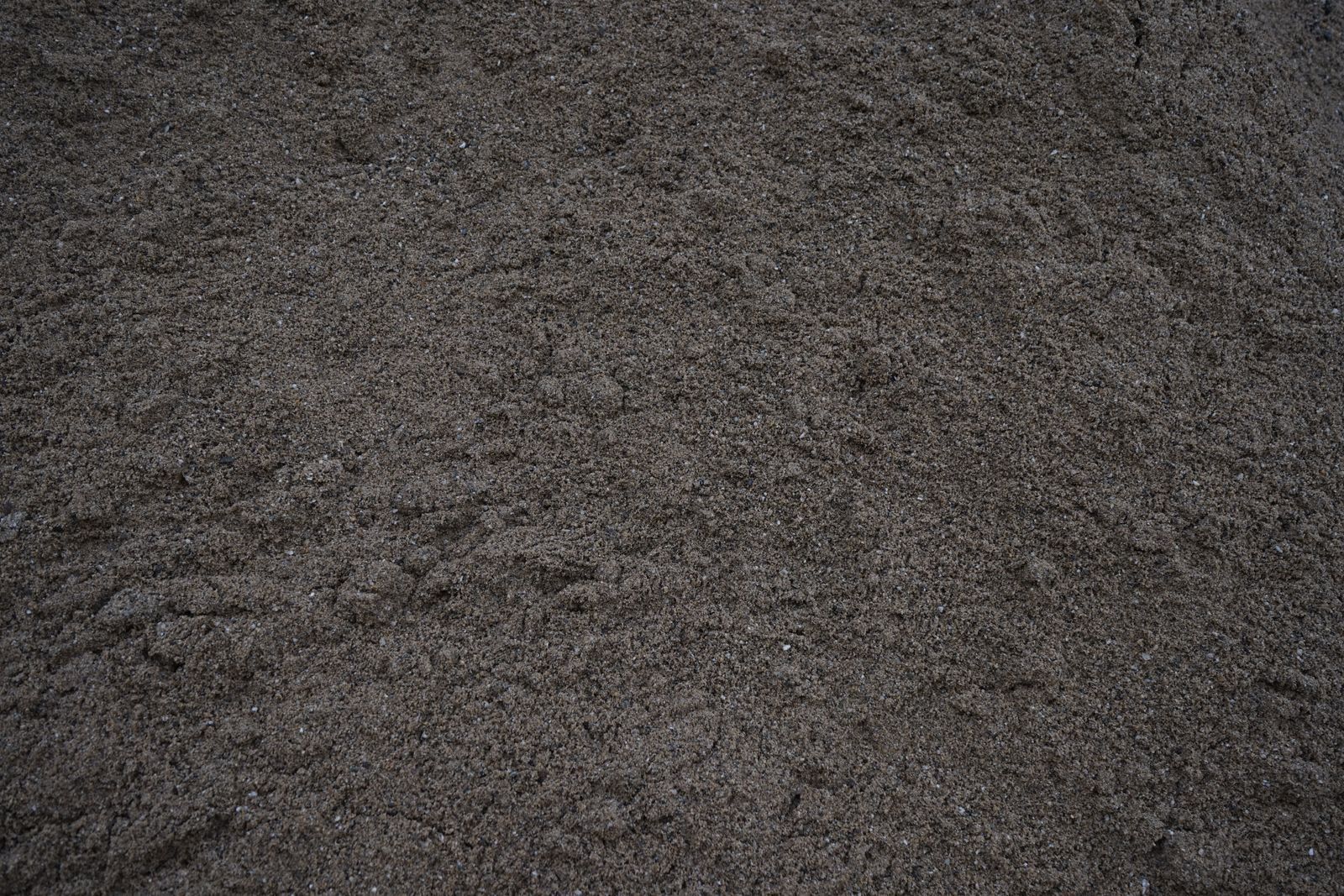 Eine Nahaufnahme eines Haufens schwarzen Sandes.