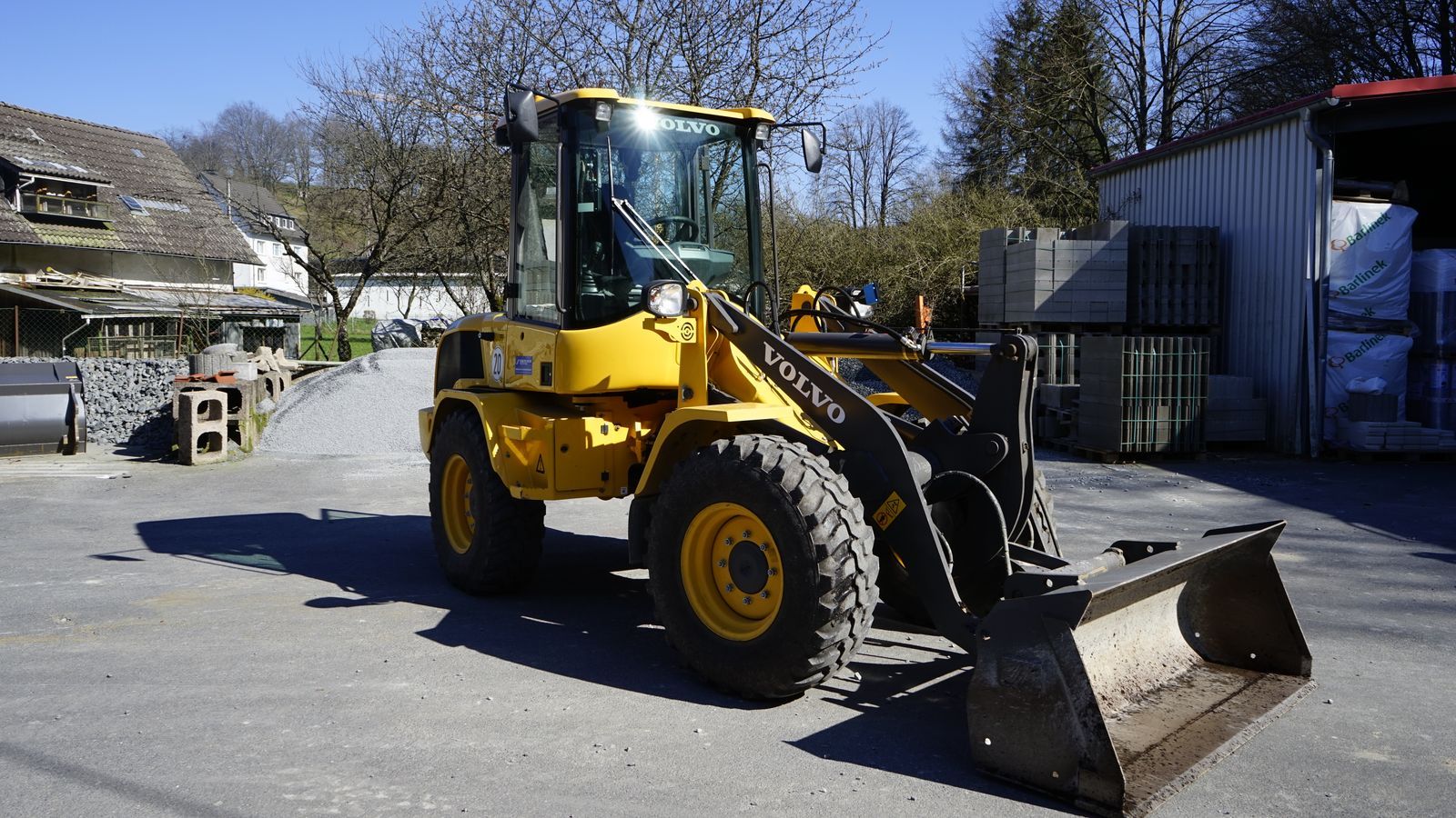 Ein gelber Volvo-Radlader steht auf einem Parkplatz