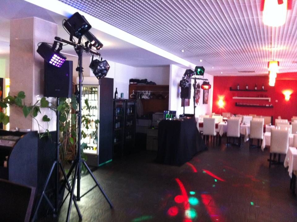 Salle de réception vide avec éclairage de scène, chaises blanches et éclairage d'ambiance rouge dans une salle de banquet moderne