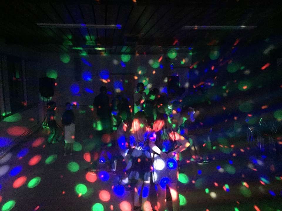 Pièce sombre avec des lumières disco rouges, vertes et bleues colorées dispersées sur le plafond et les murs