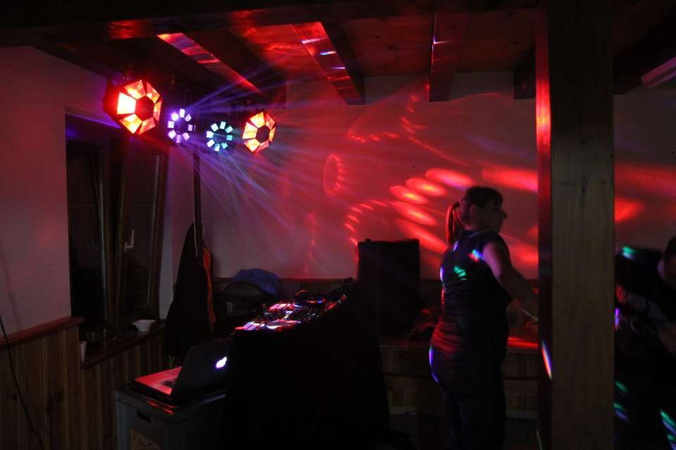 Cabine de DJ avec lumières disco rouges et violettes colorées dans une pièce sombre