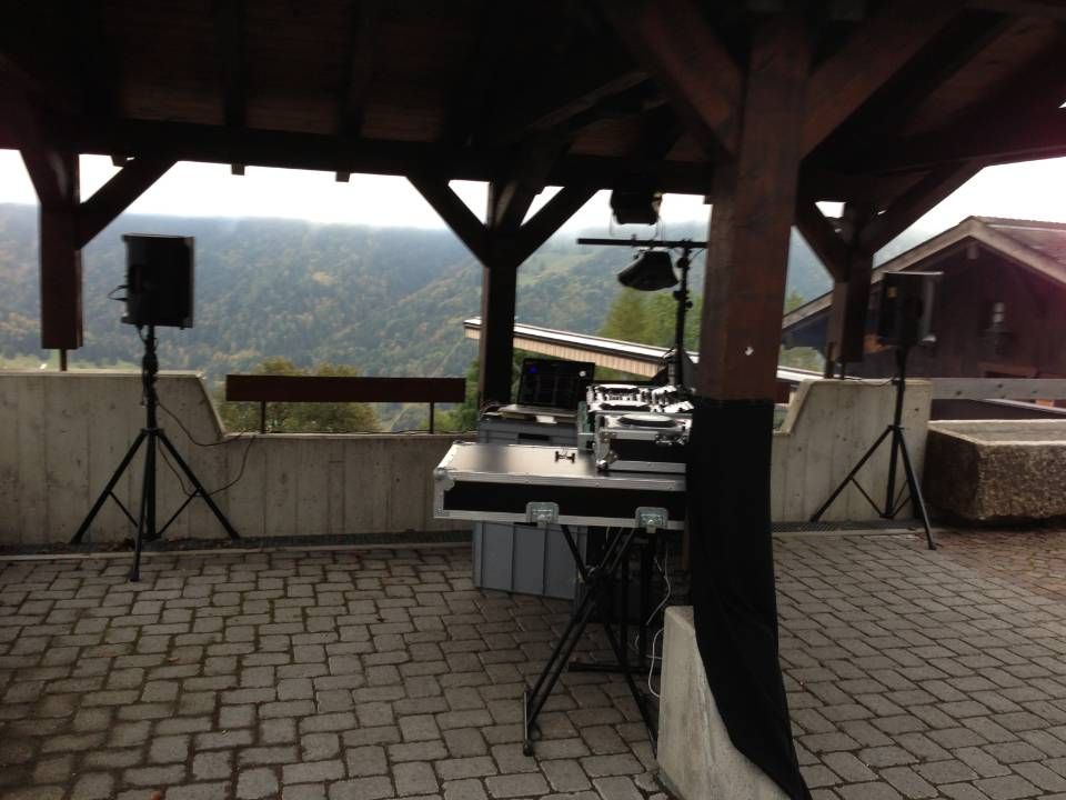 Terrasse extérieure couverte avec équipement de DJ et haut-parleurs offrant une vue sur la montagne