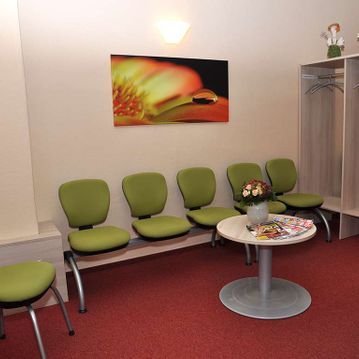 Warteraum mit grünen Sitzen