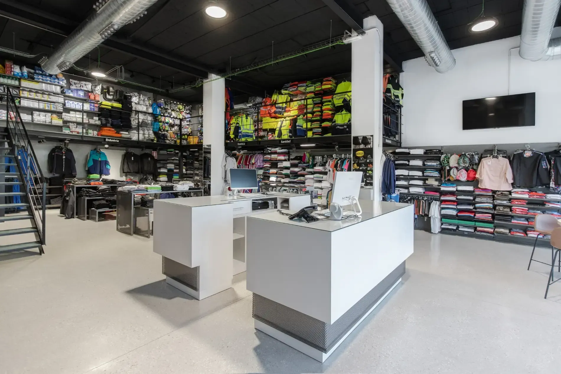 Interior de tienda minorista moderna con mostradores blancos y estantes con artículos y zapatos coloridos.