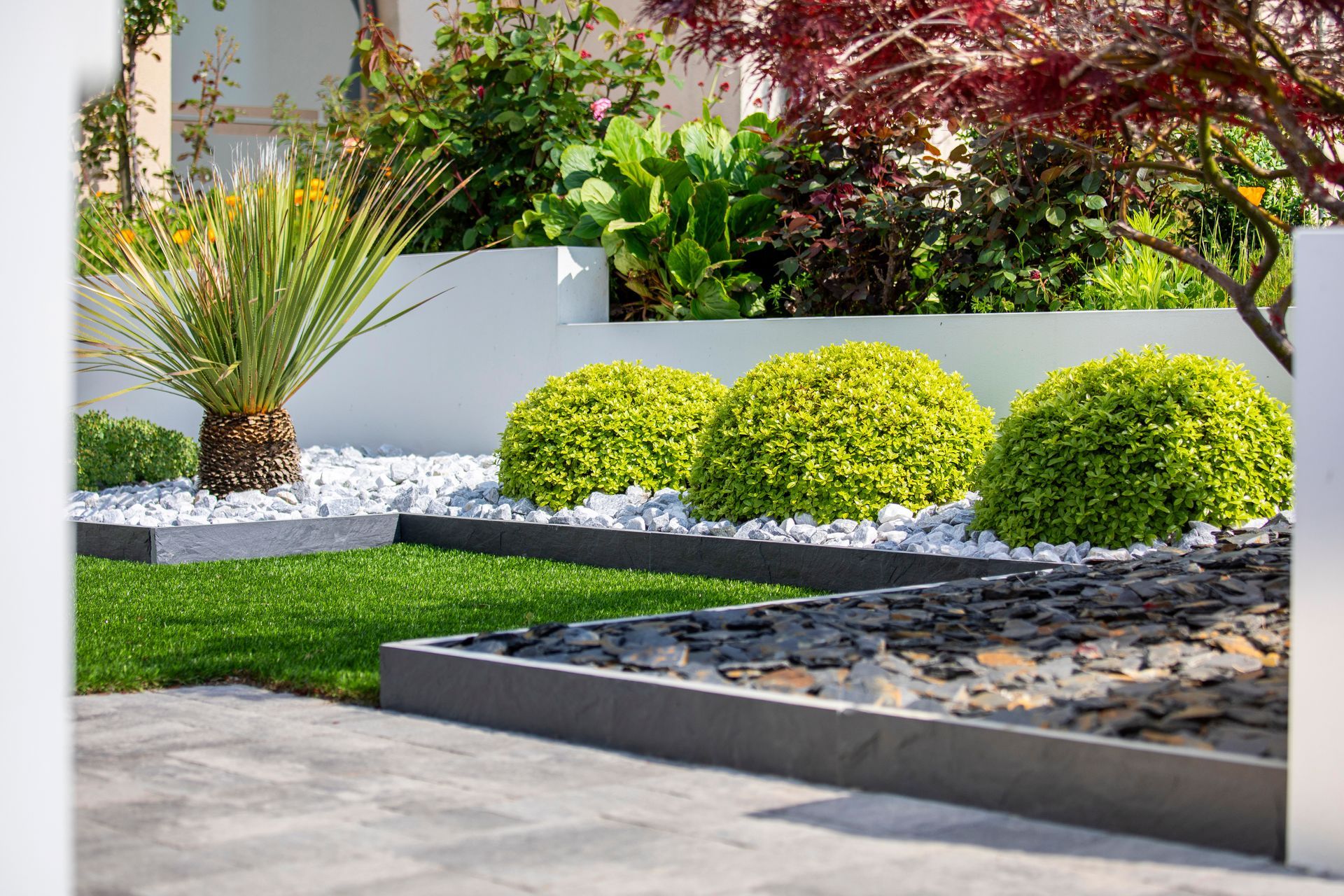 Aménagement paysager avec buissons et pierres naturelles