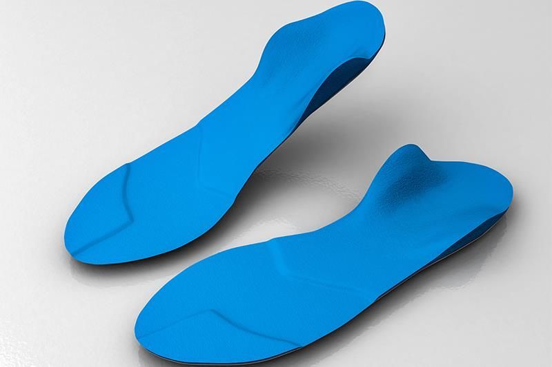 Ein Paar blaue Einlegesohlen auf weißem Untergrund
