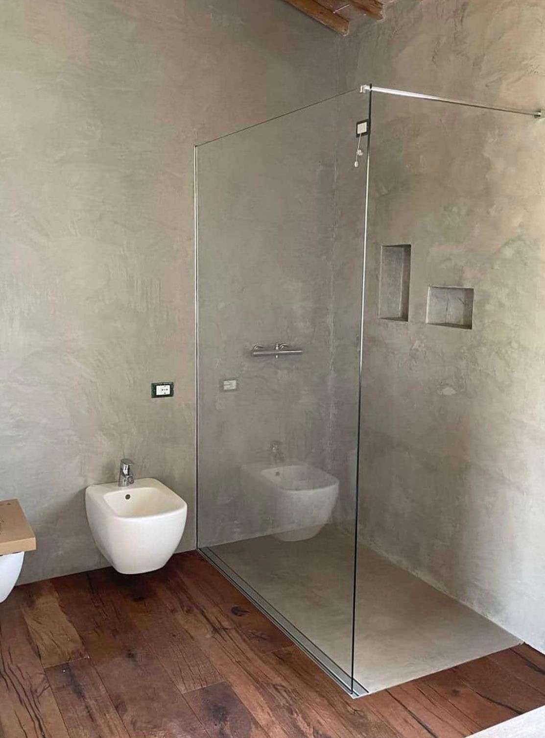 Una moderna reception con una scrivania verde lime e bianca, una porta in vetro smerigliato e una cucina sullo sfondo.